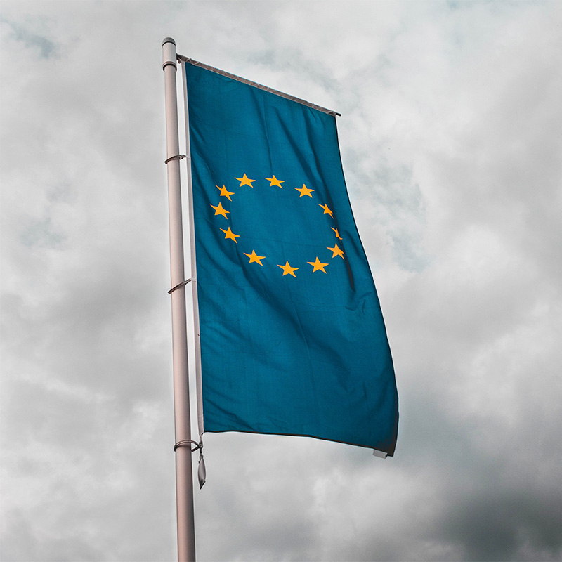 EU flag against cloudy sky.